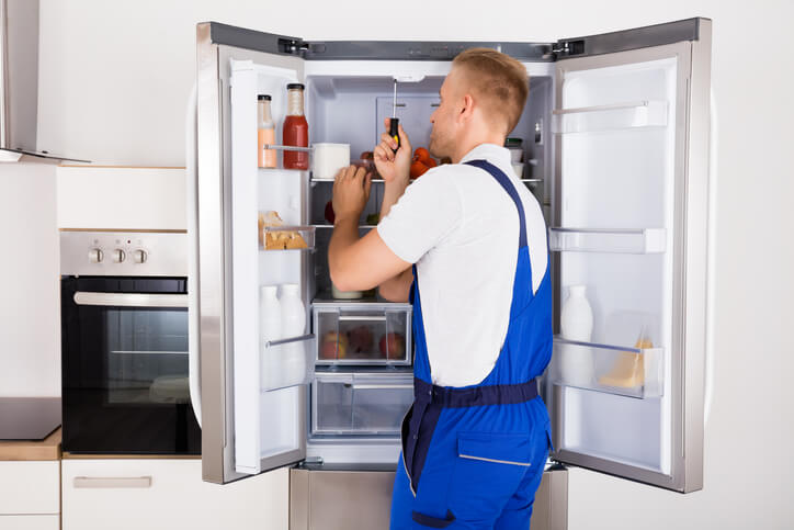 Man opening a refrigerator, emphasizing proper fridge maintenance in Keller, TX