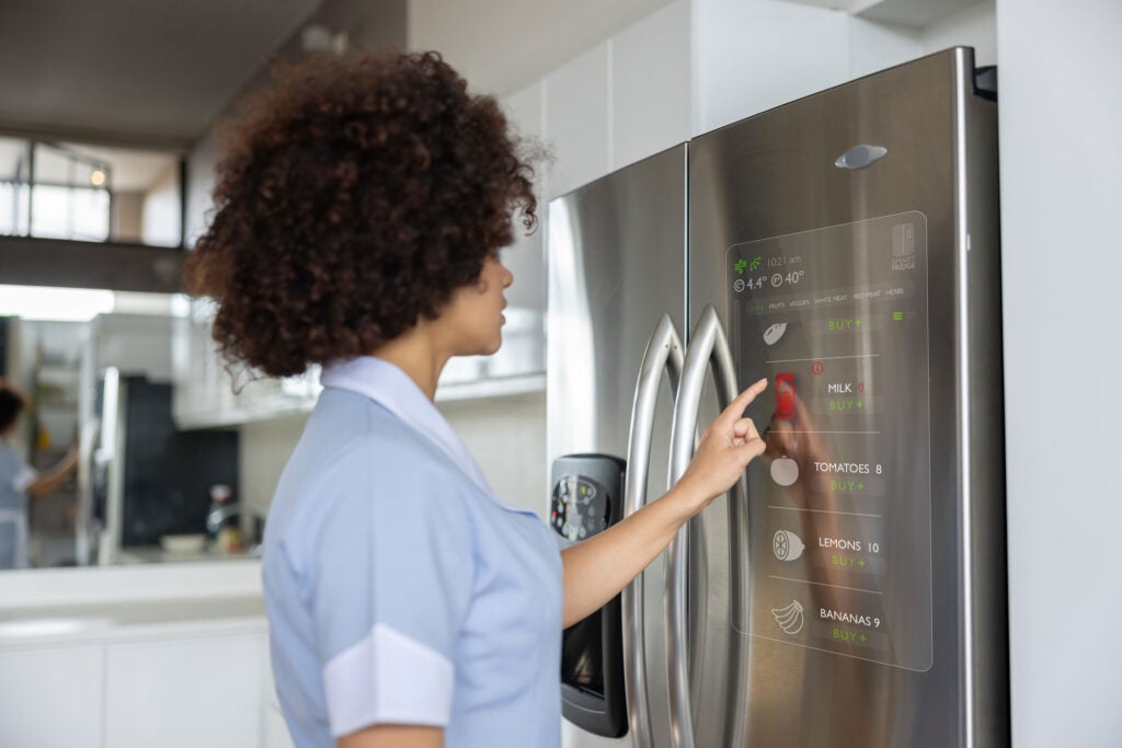 Woman using a modern refrigerator, highlighting appliance trends in Keller, TX