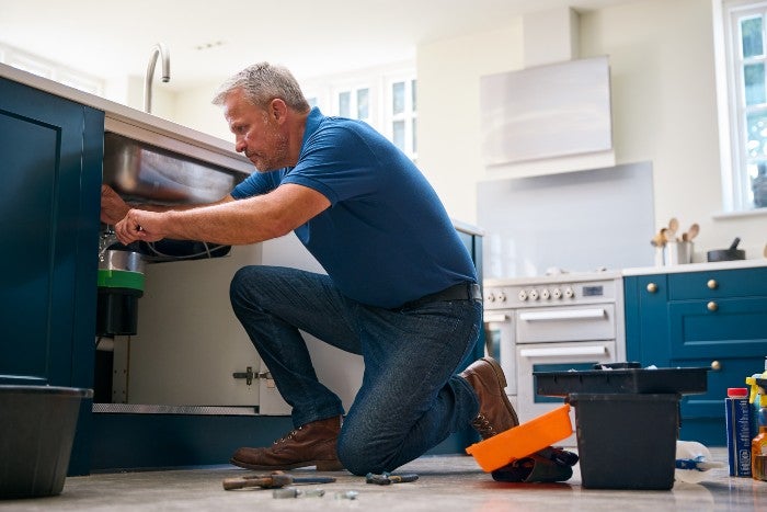Garbage disposal repair under sink to prevent plumbing issues in Keller, TX